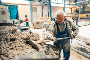 Ein Handwerker mit einer Schaufel auf der Baustelle