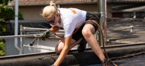 Eine Frau auf dem Dach, die schweißt